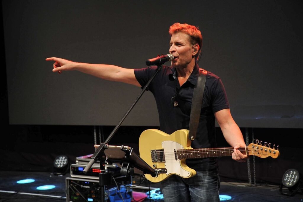Le chanteur-guitariste désigne le public depuis la scène