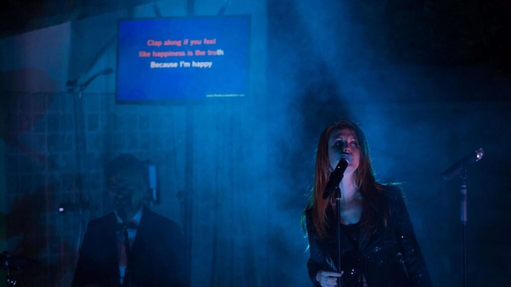 Une chanteuse au micro dans une lumière bleue tamisée