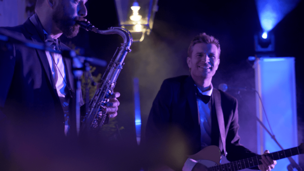 Le saxophoniste et le chanteur du groupe en costume sur scène