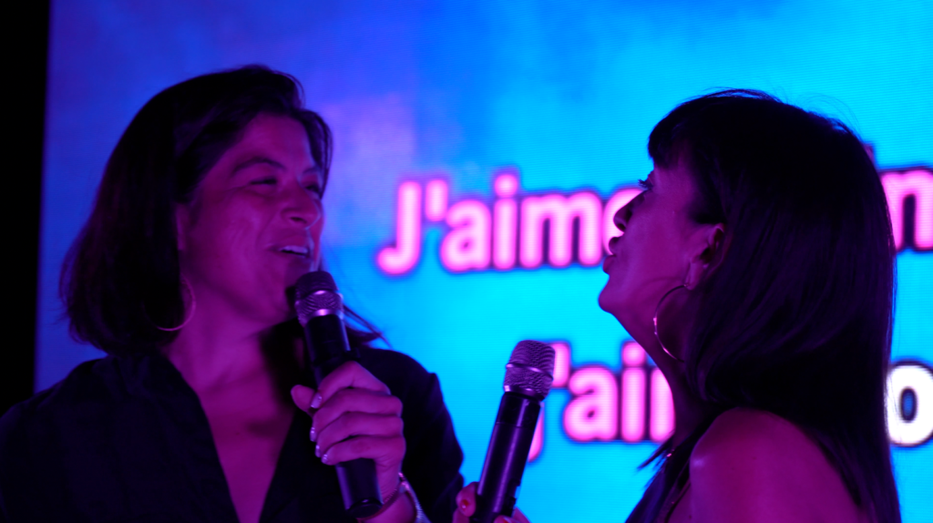 Deux candidats chantent en duo devant l'écran de paroles