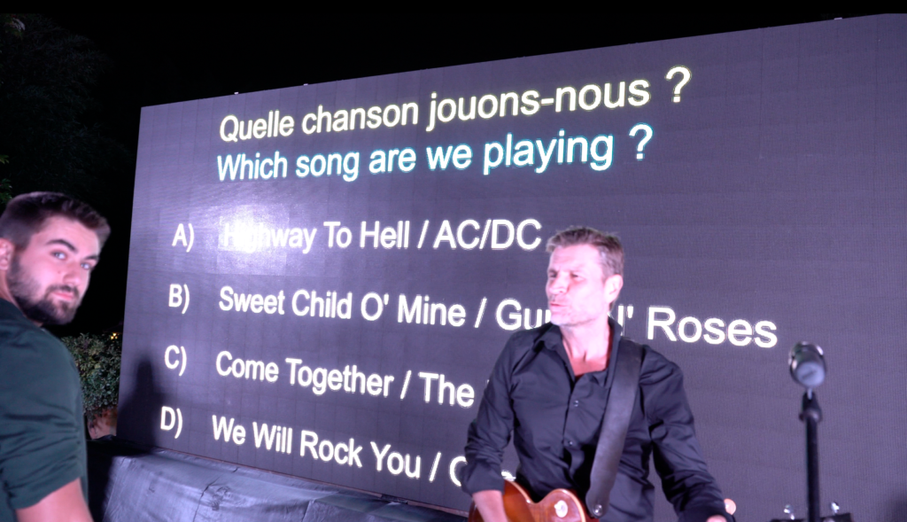 Question à choix multiples projetée à l'écran pendant que le groupe joue