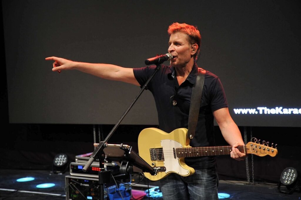 Le chanteur-guitariste du groupe désigne le public depuis la scène