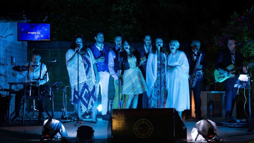 Un groupe de spectateurs aligné aux micros chante ensemble sur scène