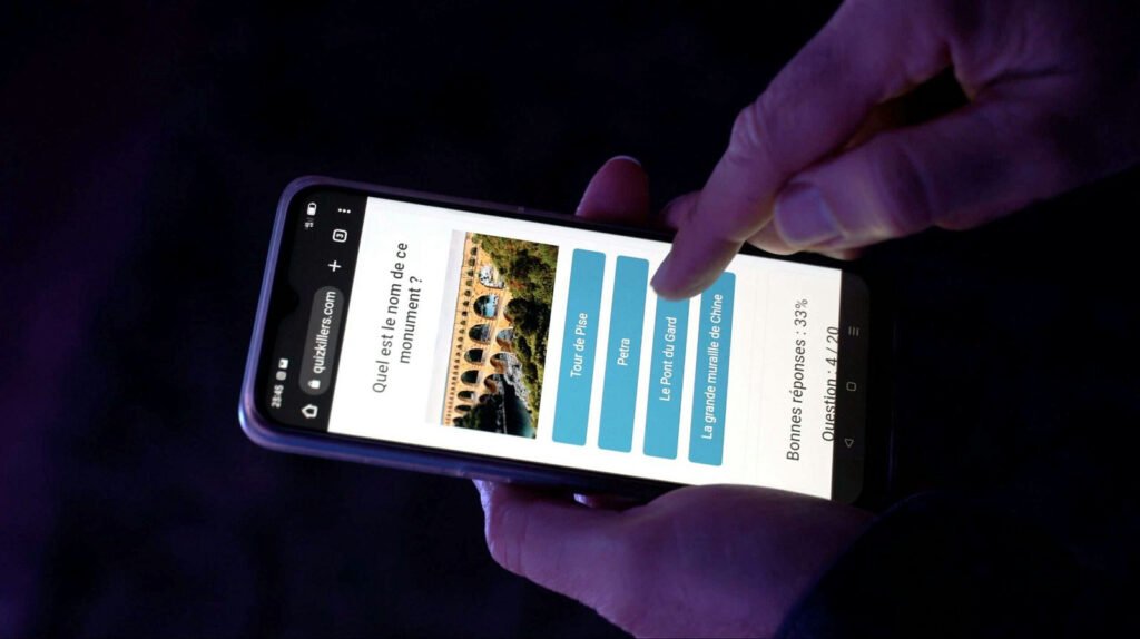 Een speler bekijkt de vraag op zijn telefoon tijdens het concert