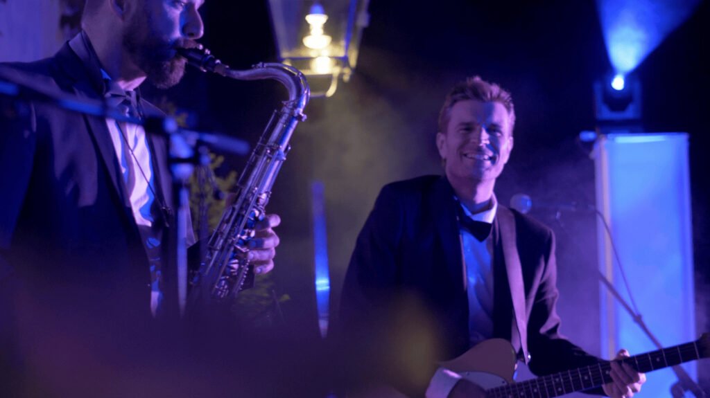 The saxophonist and the band's vocalist in suits on stage