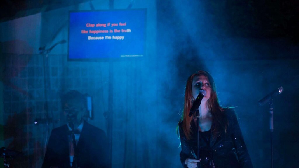 A singer at the microphone in soft blue lighting