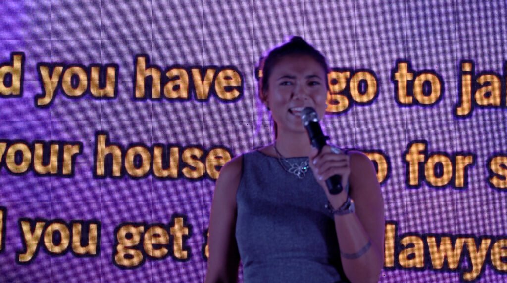 A singer carries on with the song in front of the lyrics screen