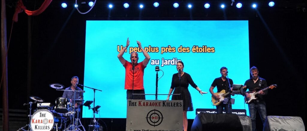 Des participants chantent sur scène avec le groupe
