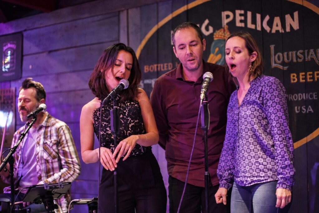 Trois participants chantent dans un pub